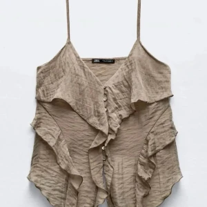 Beige volangtopp från Zara - Snygg beige topp från Zara. Helt oanvänd, strl XS. Nypris 320 kr