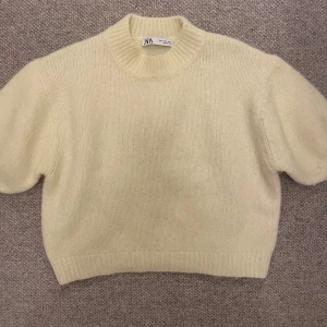 Gul stickad tröja från Zara - Säljer jättefin gul stickad tröja från Zara med korta ärmar som bara används 1-2 gånger och har därför inga defekter. Säljer på grund av att den inte kommer till användning tråkigt nog. 