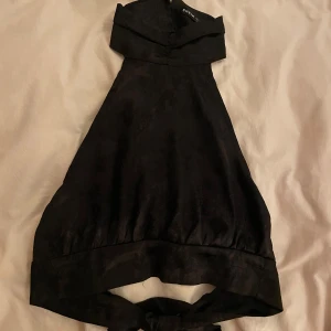 Svart topp från SHEIN - Svart typ men mönster från Shein med spänne runt halsen och öppen rygg men knytning 