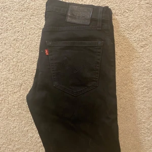 Svarta Levi’s Jeans - Snygga svarta Levi's 502 jeans med klassisk design. De har en rak passform och är tillverkade i slitstarkt denim. Perfekta för en stilren look.