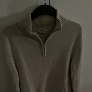 Beige stickad tröja med dragkedja - Stickad beige tröja med krage/halfsip från Cubus. Tröjan är i 158/164 men ungefär som en S.  Tröjan är i ett väldigt bra skick och endast använd fåtal gånger. Tvättas innan den säljs. 