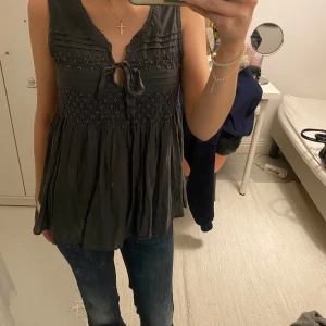 Grå odd Molly topp - Säljer en grå ärmlös topp med knytning framtill och smockdetaljer ifrån odd Molly . Toppen har en defekt på sidan, den syns inte framifrån💕Köptes för 300💕