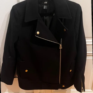 Svart kappa/ bikerjacka  - Svart kappa/ bikerjacka som är perfekt inför hösten/vintern! Säljer pga lite för stor för mig. Litet hål inuti ena ärmen därav lägre pris men det varken syns eller märks! Priset är diskuterbart!
