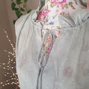 Sött bluslinne med volang & knyt - Anv en gång. Pastellgrön, ärmlös blus i detaljerat, skirt tyg. Knytning och volangkant runt halsen (finare när struken). Passar S. ~ STOR rensning i min shop ~ Välj 5 för 100kr oavsett pris, skicka medd/lämna som prisförslag (gäller där det står) ~