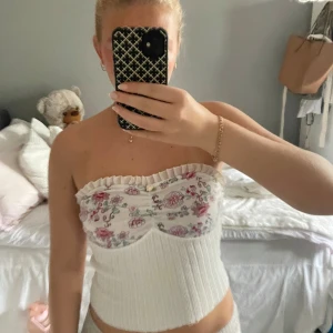 Supersöt tubtopp - Blommig tubtopp med volang. Liten slitning längst ner på ett ställe (se sista bilden). 🌸