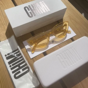 Chimi solglasögon  - Helt nya chimis i färgen mango 006. Allt tillkommer-dvs asken, etuiet, dustbagen.