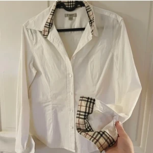 Skjorta  - Äkta Burberry, figursydd damskjorta. I storlek L men en aning mindre i storlek. OBS. Finns inget kvitto eller ”dustbag”
