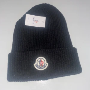 Moncler mössa - En till mössa helt oanvänd. Samma sak med denna vet inte om den är äkta men den ser bra ut.