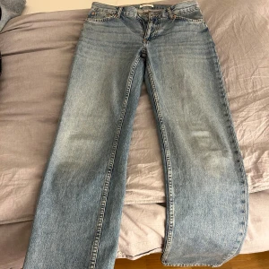 Blåa jenans - Blåa kort midjade jeans som är utsvängda vid benen. Jeansen är i mycket god skick. Storleken är 36.