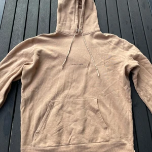 Saint Laurent hoodie - Tjena, säljer nu denna riktigt snygga och populära saint Laurent hoodien, den är i bra skick utöver att tagsen är avklippta, den är beige/brun, hör av er vid frågor och funderingar🙌🤝