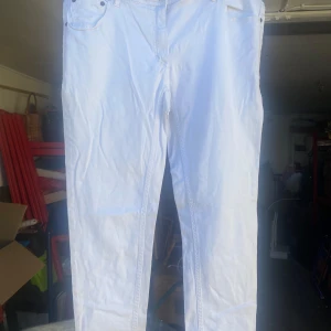 Vita byxor från H&M - Säljer ett par vita byxor från H&M i storlek 44. De är i bra skick och perfekta för både vardag och fest. Byxorna har en klassisk design med fickor fram och bak.
