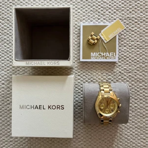 Guldig klocka från Michael Kors - Sparsamt använd. Jättefin modell i guld. Mått: Ø35mm. Modellen heter ”Bradshaw”. Fler bilder kan skickas vid önskemål 🤗⌚️ Kom med prisförslag vid intresse!