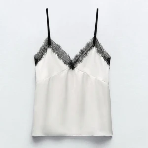 Svart/vitt spetslinne - Säljer detta jättesöta och trendiga linne från Zara, knappt användt och därav i nyskick. Hör av dig vid fråger!  (‼️Gå gärna in på mitt konto och köp en bundle, jag säljer stickade tröjor, fler spetslinnen och lowwaisted jeans‼️)