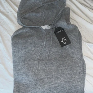 Cashmere Hoodie - Säljer en riktigt snygg å skön Cashmere hoodie från Carmés, helt ny med prislappen kvar perfekt nu till hösten och vintern. Strl M, priset är ej hugget i sten!