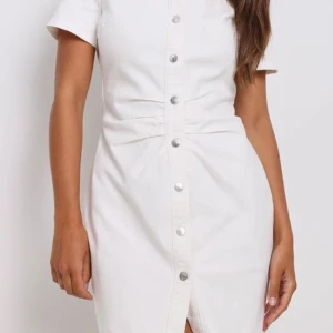 Vit klänning från NA-KD - Säljer en superfin vit klänning från NA-KD. Den har korta ärmar och knappar hela vägen ner, vilket ger en snygg och stilren look. Perfekt för både vardag och fest! Klänningen är i storlek 36 och sitter som en smäck.