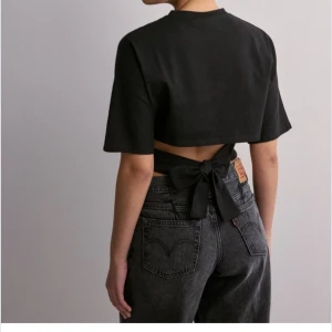 Svart kortärmad topp med knyt - Säljer min super fina open back tie tee topp från nelly som tyvärr inte kommer till användning🩷 kan tänka mig att sänka priset vid snabb affär