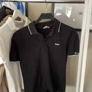 Boss piké  - Hel svart boss piké med vita detaljer, säljer för 425 kr men priset kan diskuteras 👍🏻