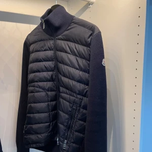 Moncler cardigan - Säljer denna feta moncler cardigan i färgen navy! Storlek M men passar S då den är lite mindre i storlek. Skicket är 8/10 väldigt bra skick endast en liten reva på handleden (se bild 4) köpt på Garmsmarket! Hör av er vid minsta fundering