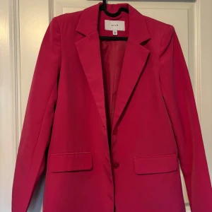 Rosa kavaj - Väldigt bra skick, använd en gång. Rosa kavaj med axelvaddar, i storlek 34. Lätt figursydd, lite längre modell. 