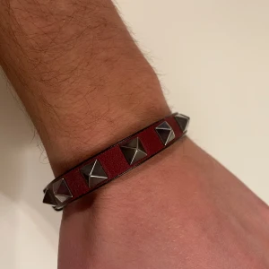 Valentino armband - Valentino armband i vinröd. One size fits all. Köpt på Farfetch, kvitto finns.
