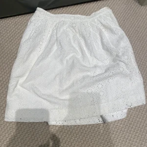 Vit kjol från Polo Ralph Lauren - Säljer en superfin vit kjol från Polo Ralph Lauren i storlek 10 år. Kjolen har ett vackert broderat mönster och en praktisk dragkedja med knapp i sidan. Perfekt för sommarens alla tillfällen!