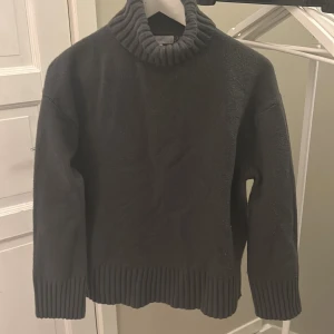 Mörkgrå polotröja från H&M - Säljer en stilren mörkgrå polotröja från H&M i storlek M. Tröjan är stickad och har långa ärmar med ribbade muddar och nederkant. Perfekt för höst och vinter för en mysig och varm look. Passar både till vardags och lite finare tillfällen.