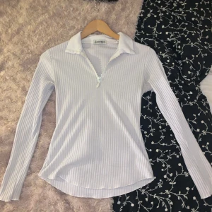 Vit ribbad tröja från Sancred - Säljer en snygg vit ribbad tröja från Sancred. Den har en dragkedja framtill och en klassisk krage. Perfekt för både vardag och träning! Tröjan är i bra skick men väldigt använd då den har några år på nacken. Lite nopprig och den är inte helt kritvit längre. 