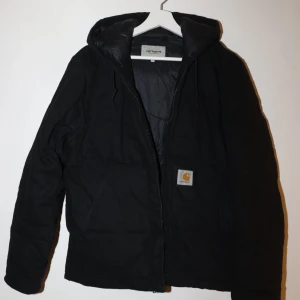Carhartt Brooke Jacket  - Säljer en svart jacka från Carhartt i bra skick. Supervarm och skön. En liten rödaktig fläck på baksidan och en vit fläck på insidan av jackan, syns på bilderna 4&5. Nypris 3800kr. 