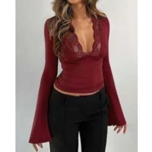 Röd spetstopp - Snygg vinröd topp med långa ärmar och v-ringad spetsdetalj. Perfekt för höst och vinter, den är både elegant och bekväm. Passar bra till både fest och vardag.