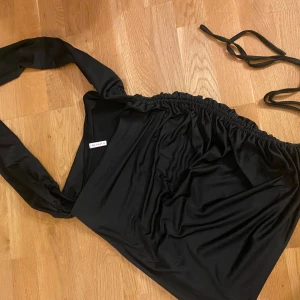 Svart klänning från D&M - Snygg svart klänning från D&M i storlek M. Den har en enkel och stilren design med knytband.