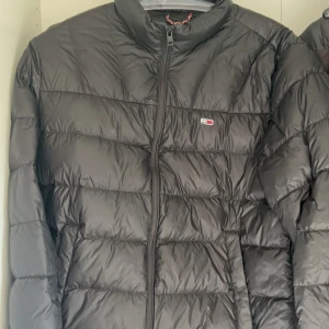 Svart dunjacka från Tommy Hilfiger - Denna jacka kommer inte till användning så ofta tyvärr men den är väldigt snygg och passar perfekt året runt. Knappt använd och inga fel på den.