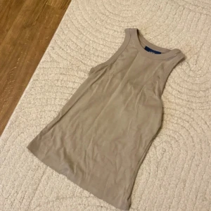 Beige linne / topp från JJXX - Säljer en stilren beige ärmlös topp från JJXX. Perfekt för sommardagar eller som ett lager under en jacka. Toppen är i ett mjukt och bekvämt material, vilket gör den idealisk för både vardag och träning.