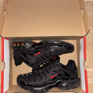 Svarta Nike sneakers med röda detaljer - Säljer ett par svarta Nike sneakers i mycket bra skick. 
