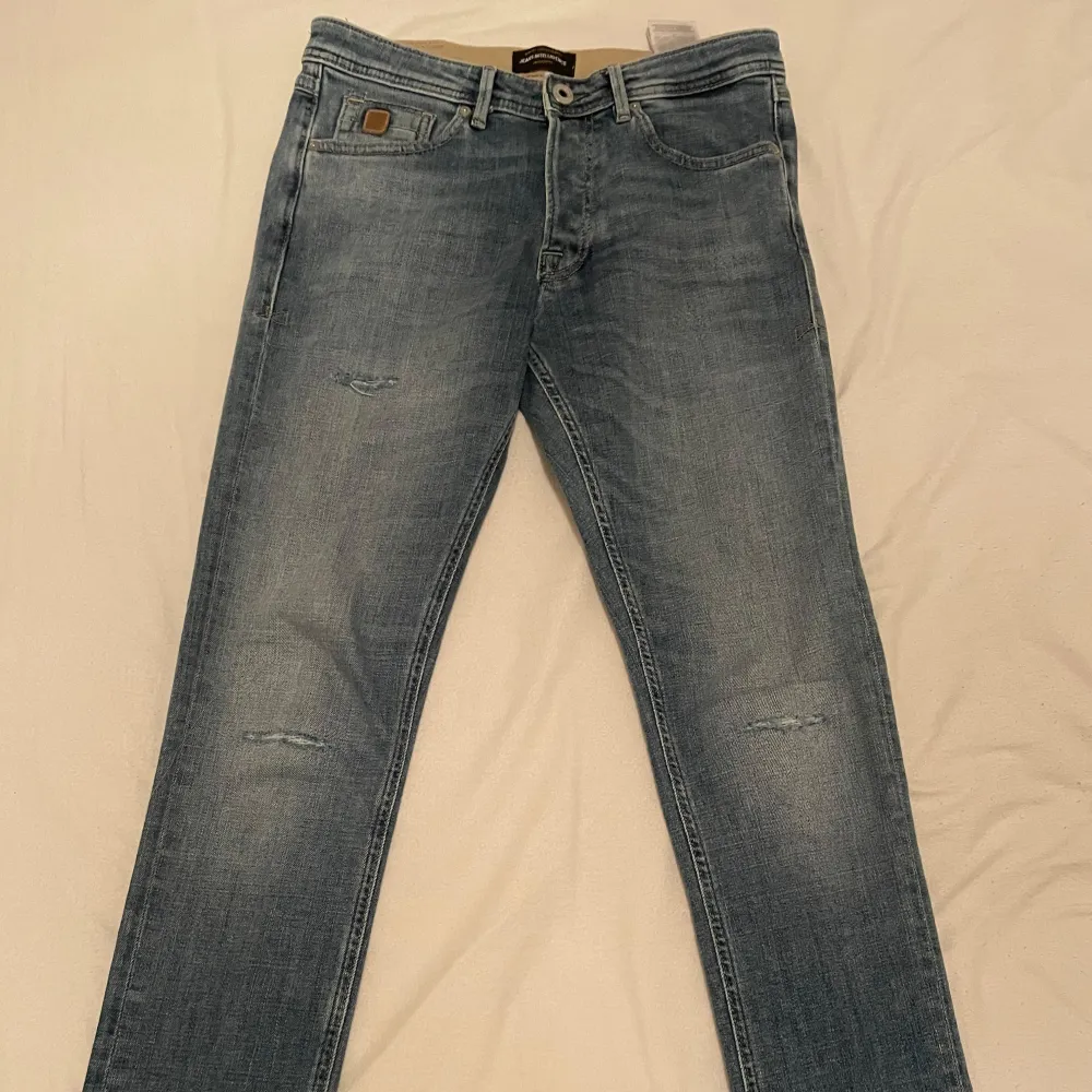 Säljer ett par snygga blå Slim-Glenn jeans från Jack & Jones. De har en slim passform och är i bra skick med en lätt slitning för en cool look. Perfekta för både vardag och fest! 🕺 NYSKICK!! NYPRIS 1045,00kr!!! Priset kan diskuteras!. Jeans & Byxor.