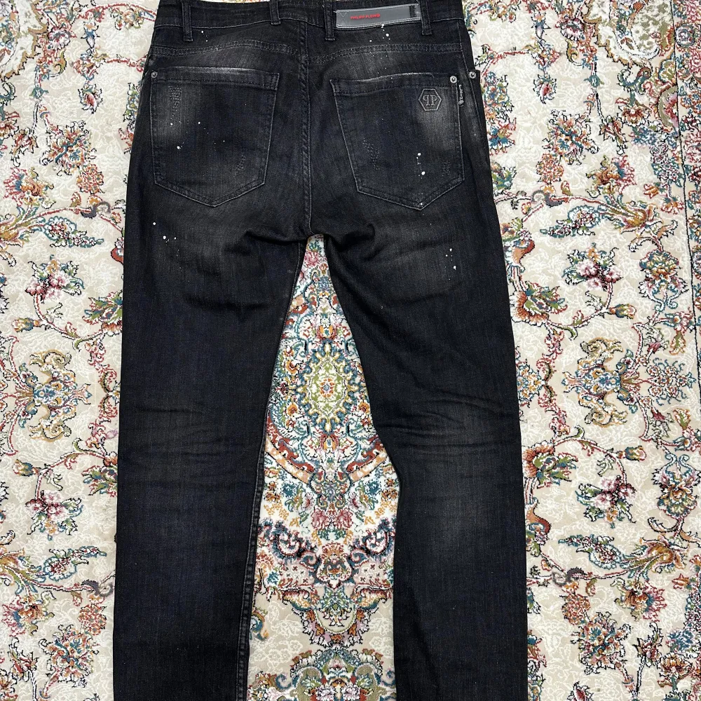 Philipp Plein jeans i bra skick. De har en cool, sliten look med små färgstänk och en snygg logga på bakfickan. Den är slimfit och passar fint . . Jeans & Byxor.