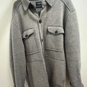 Grå overshirt från Holebrook Sweden - Säljer en snygg grå overshirt från Holebrook Sweden i storlek L. Den har en stilren design med knappar och två stora bröstfickor. Perfekt för höst och vår, och den är i mycket bra skick. Passar både till vardags och lite finare tillfällen.