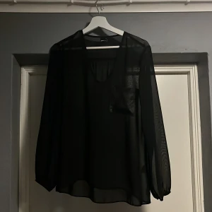 Svart blus  - En svart blus från Gina tricot med ficka på bröstet (ganska genomskinlig)
