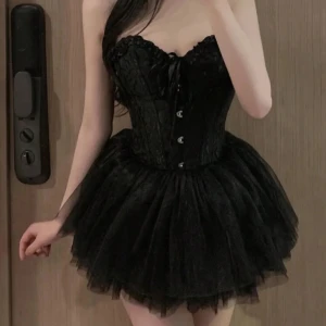 Svart och vit korsettklänning - Säljer svart fluffig tyllkjol, fluffig tyllkjol. Perfekt för fest eller en speciell kväll! Skulle säga att det finns ingen speciell storlek utan den passar från S och uppåt
