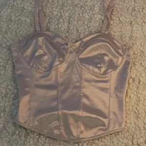 Rosa linne - Rosa crop linne med satin material med bomull på insidan och en rosett!  Använd några gånger, men har inga skador och är i generellt bra skick! 