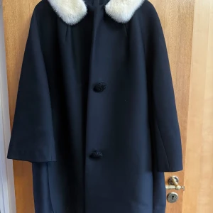 kappa med pälskragae - hemsydd kappa med otagbar pälskrage i äkta päls. kappan är i xl och är rymlig, har sidofickor och hemmsydda knappar