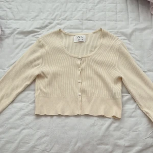 En jättefin kofta  - En jättefin beige kofta som passar 12-13 åriga men den är kort men väldigt fin under en klänning eller så .