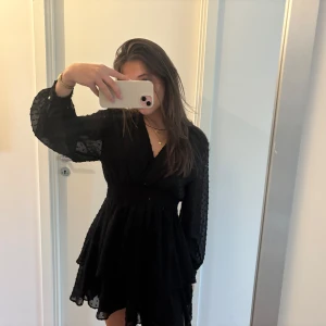 Svart omlottklänning - Säljer en superfin svart klänning med långa ärmar och volangdetaljer. Perfekt för både fest och höstvardagen.🍁✨ Klänningen har en elegant passform och är gjord i ett lätt och bekvämt material. Passar perfekt för en kväll ute eller en speciell tillställning.🖤