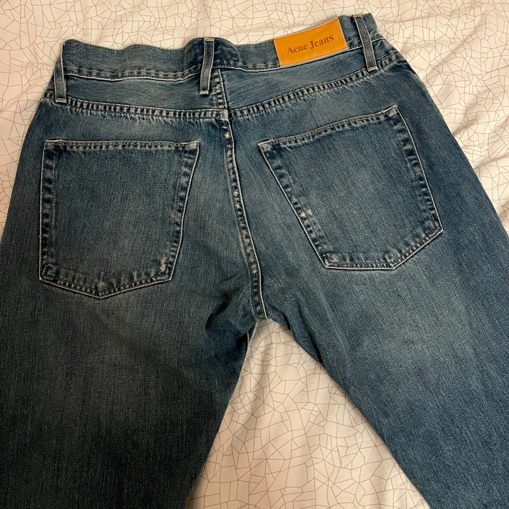 Snygga blåa ACNE jeans för män i storlek 30/34. Fina detaljer med små slitningar och annars mycket bra skick. Vid snabb affär kan prissänkning ske. Dock saknas knappen där fram men med bälte så syns det inte!. Jeans & Byxor.