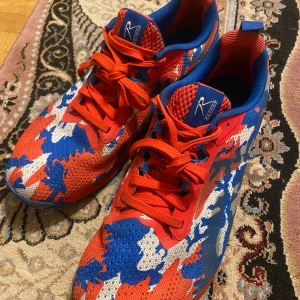 Färgglada sneakers från Reebok - Säljer ett par riktigt coola Reebok sneakers i ett färgglatt mönster med rött, blått och vitt. Skorna har snörning och är i mycket bra skick. Perfekta för träning eller en färgglad vardagslook. Storlek herr 44, tillverkade i Vietnam.