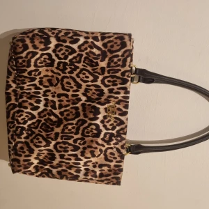 Viktoria secret väska leopard - Väldigt fin och praktisk väska ifrån victoria secret i leopard mönster, säljer denna för den används inte kan diskutera pris