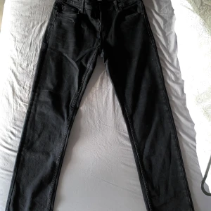 Svarta jeansbyxor - Säljer ett par svarta jeansbyxor i bra skick. De har en klassisk femficksdesign och är perfekta för både vardag och fest. Byxorna har en normal passform och är tillverkade i ett slitstarkt material. Perfekta för höst och vinter!