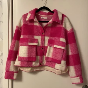 Rutig rosa och vit jacka från Zara - Superfin rutig jacka från Zara i rosa och vitt. Den har en skön och varm känsla, perfekt för höst och vår. Jackan har långa ärmar och knappar framtill. Jackan är storlek 164 och motsvarar XS i dam storlek. Den är i bra skick och redo för nya äventyr!