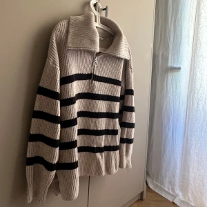 Beige och svart randig stickad tröja från Stockh LM - Säljer en supermysig beige stickad tröja från Stockh LM med svarta ränder. Den har en dragkedja framtill och en stor krage 🖤🤍