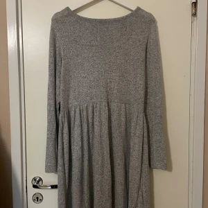 Grå långärmad klänning från 157 - Mysig grå klänning från 157 i storlek S. Den är långärmad och perfekt för höst och vinter. Klänningen har en enkel och stilren design som passar både till vardags och lite finare tillfällen. Oanvänd 