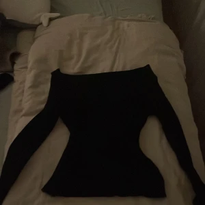Svart långärmad tröja - Snygg svart långärmad shoulderless tröja med en tight passform. Perfekt för kyligare dagar och kan enkelt matchas med olika outfits. Ett måste i garderoben för en stilren look. Aldrig använd helt ny       Org pris:279kr